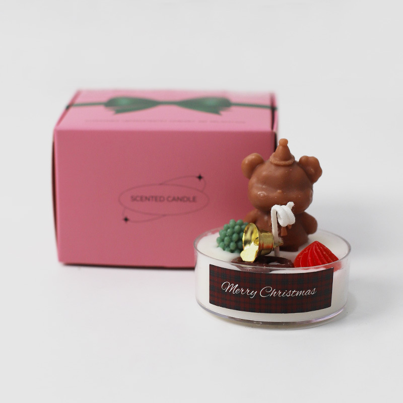 Petit ours de Noël en forme de bougie chauffe-plat portant un chapeau.