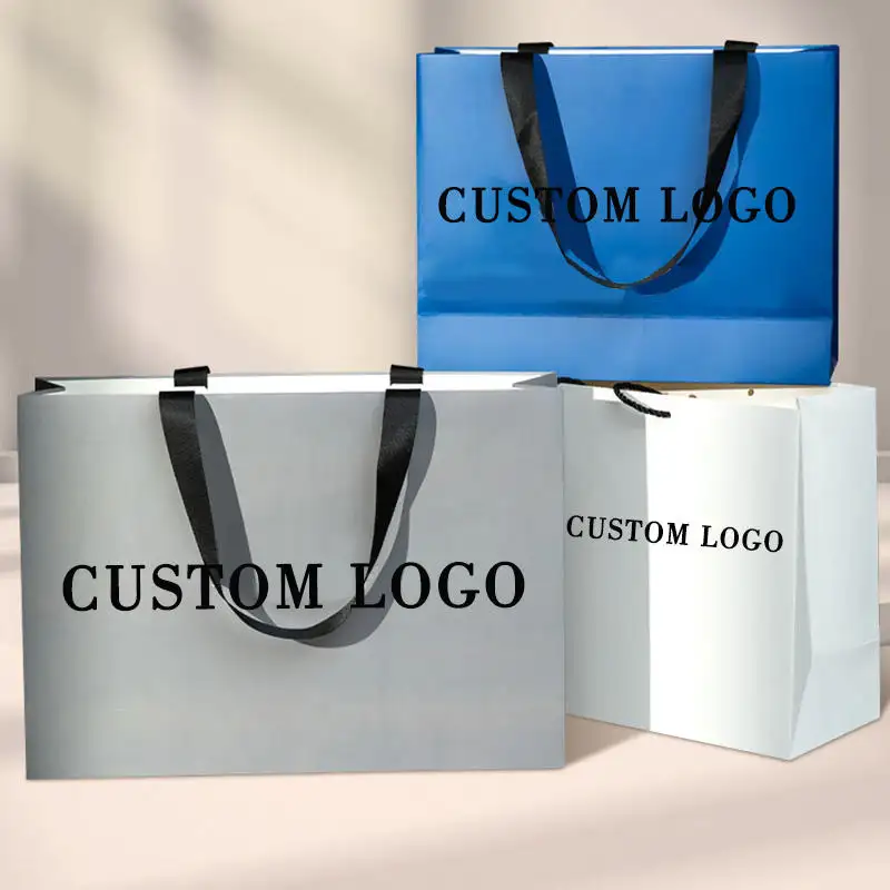 Bolsas de papel de compras de cartón blanco de lujo con impresión de logotipo personalizado con asa de cinta para embalaje de ropa de zapatos