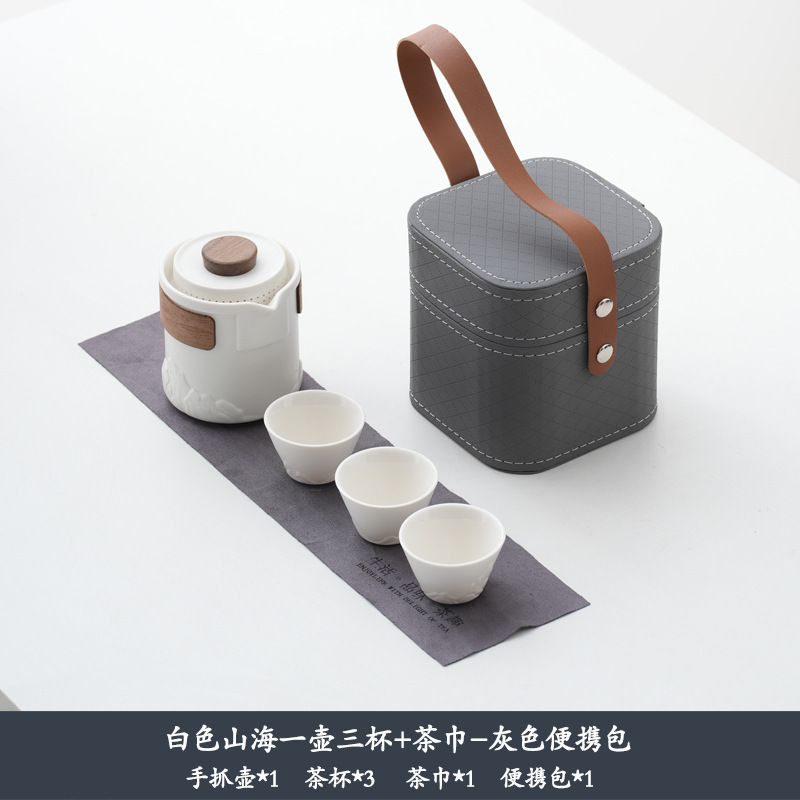 Ensemble montagnes blanches et mer, une théière, trois tasses, sac gris