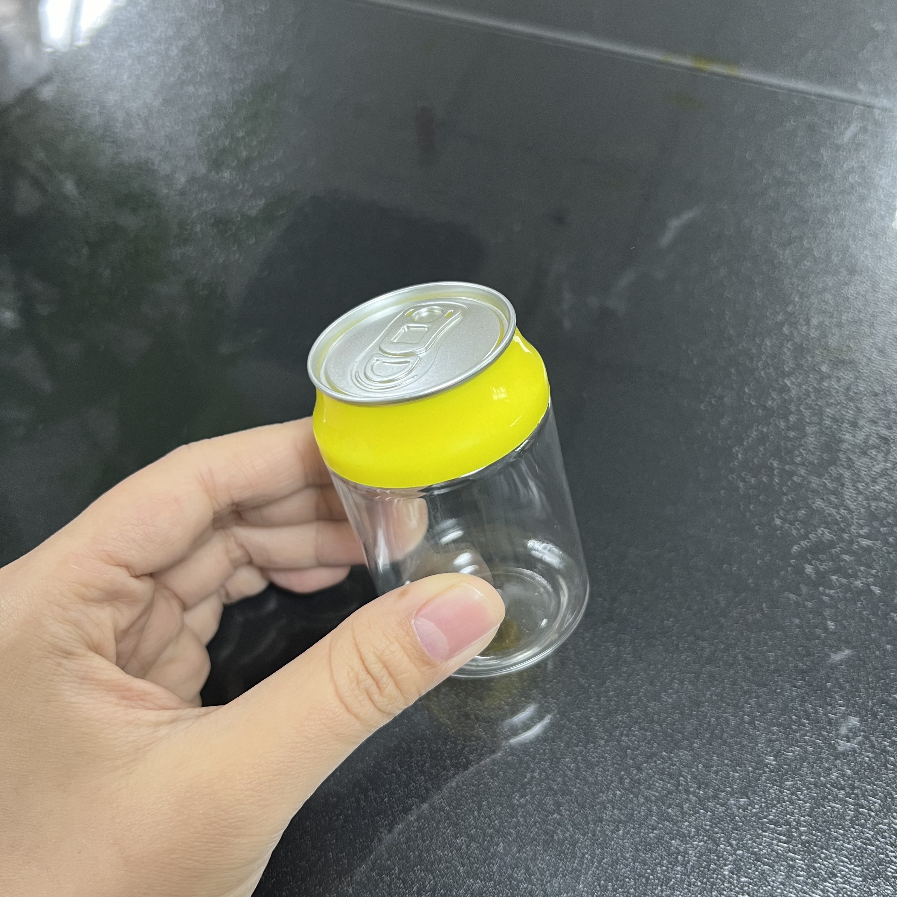 Botella transparente con tapa amarilla (parte superior plateada)