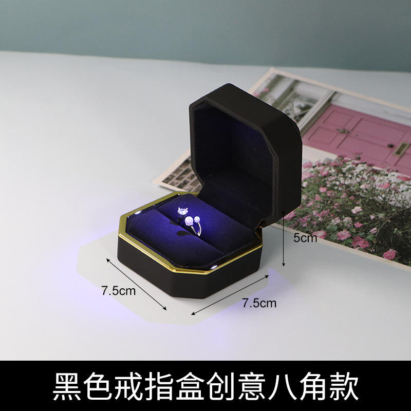 Boîte à bagues noire octogonale lumière bleue