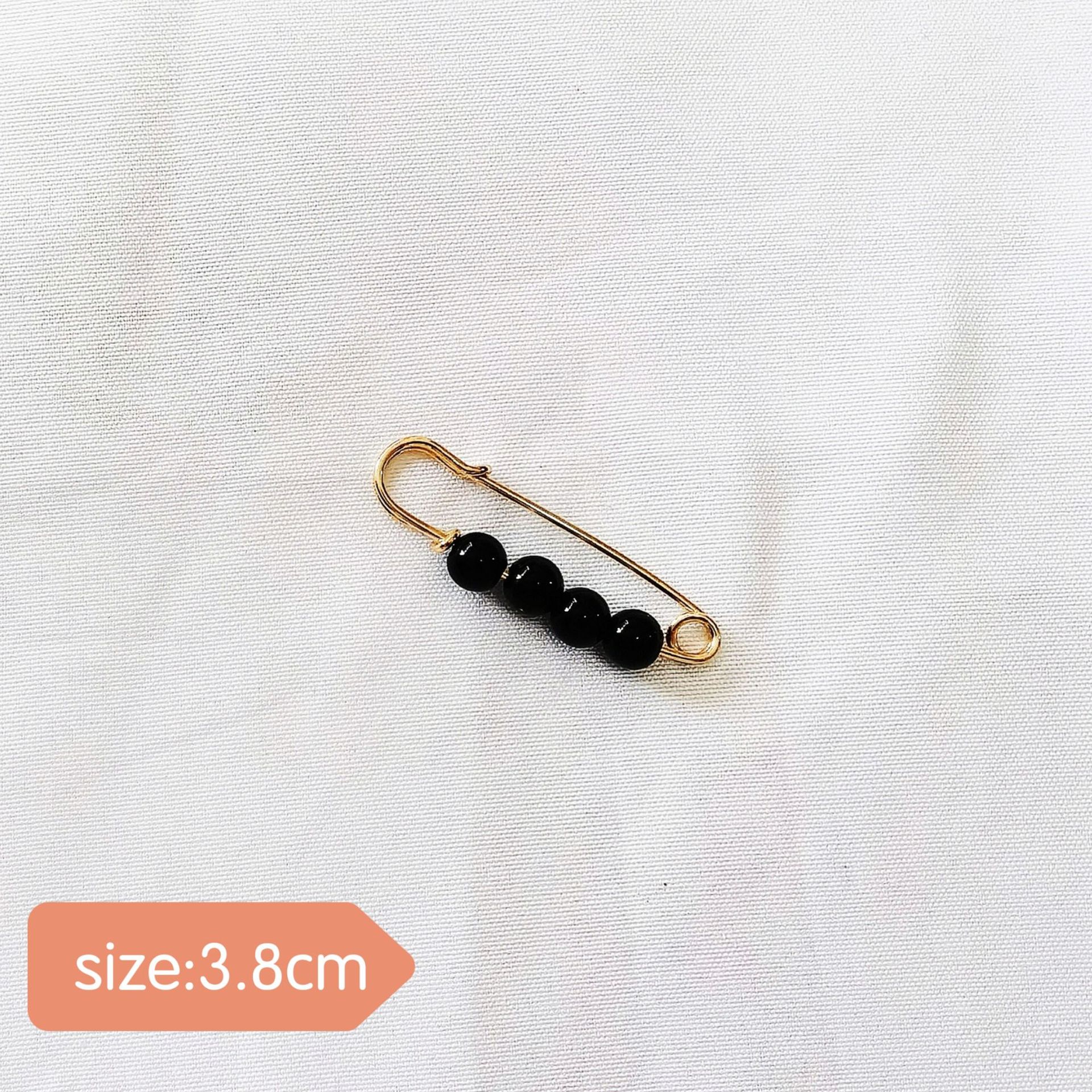 Pines 16#Cuatro cuentas negras, aguja dorada, 3.8 cm.