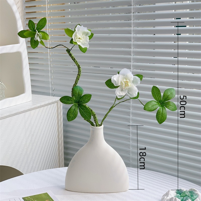 Un rhododendron blanc dans une bouteille plate et simple