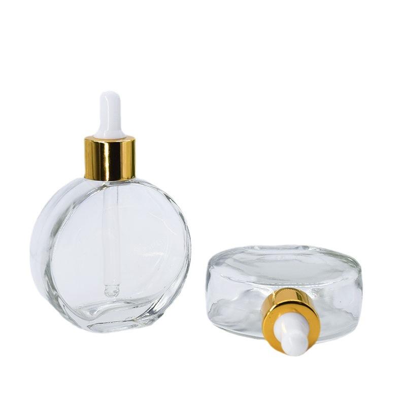 Clear glass bottle with gold dropper