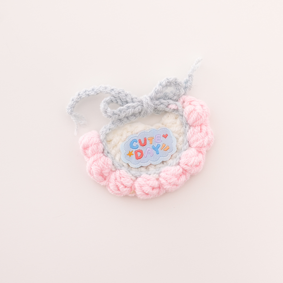 Bib with white background, pink trim, and blue lettering