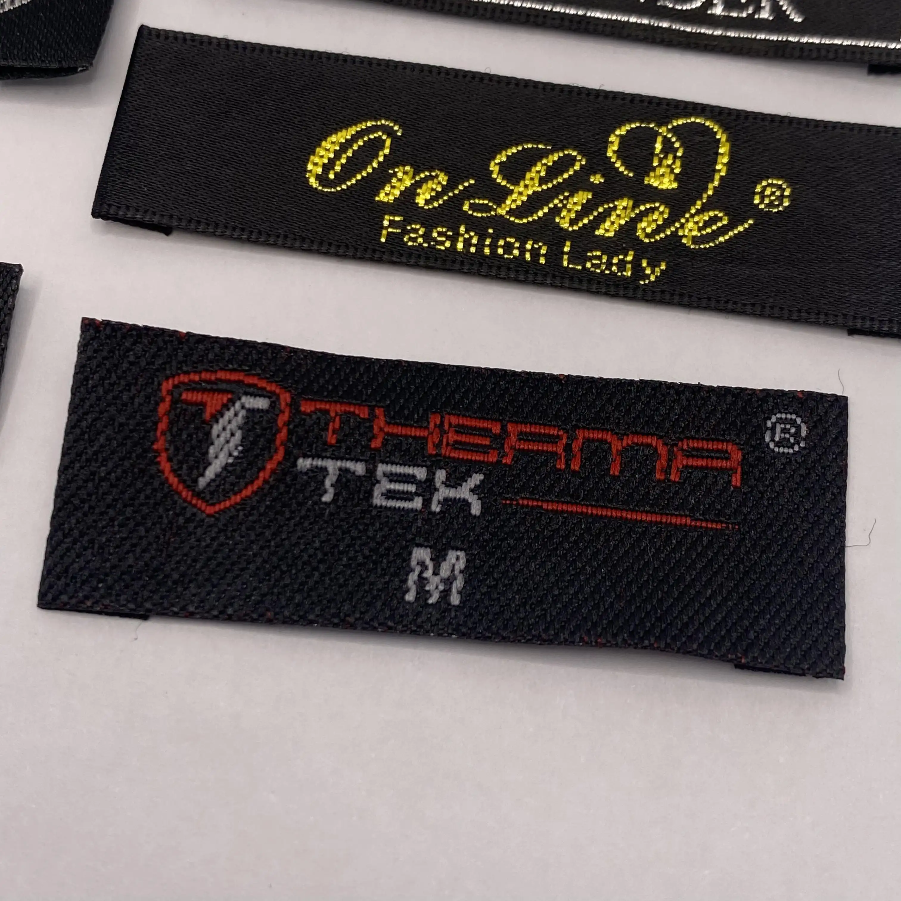 Accesorios de ropa Logotipo de marca personalizado Tela de poliéster de alta densidad Etiqueta tejida Etiquetas de cuello principal