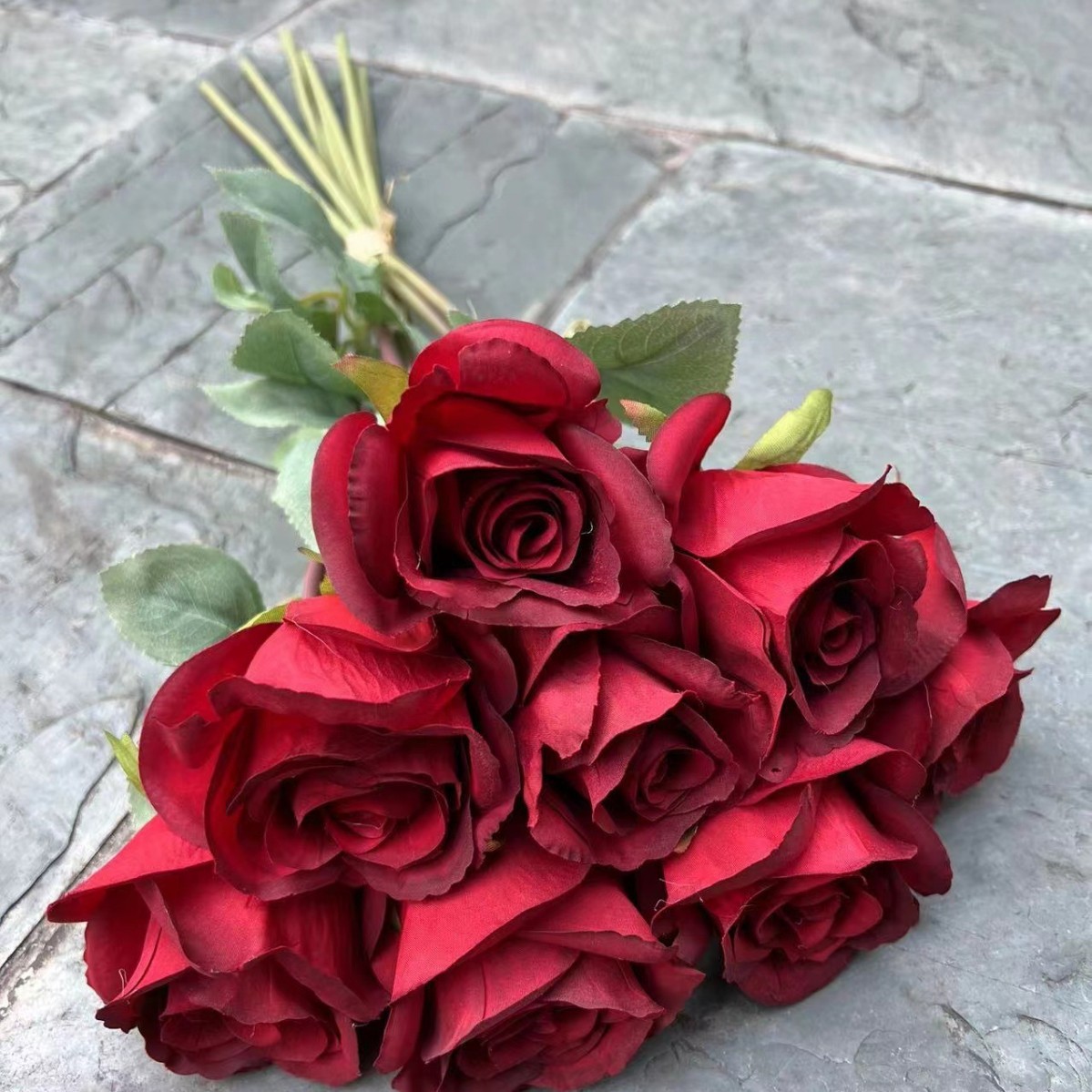 8 manos sosteniendo una rosa barroca roja