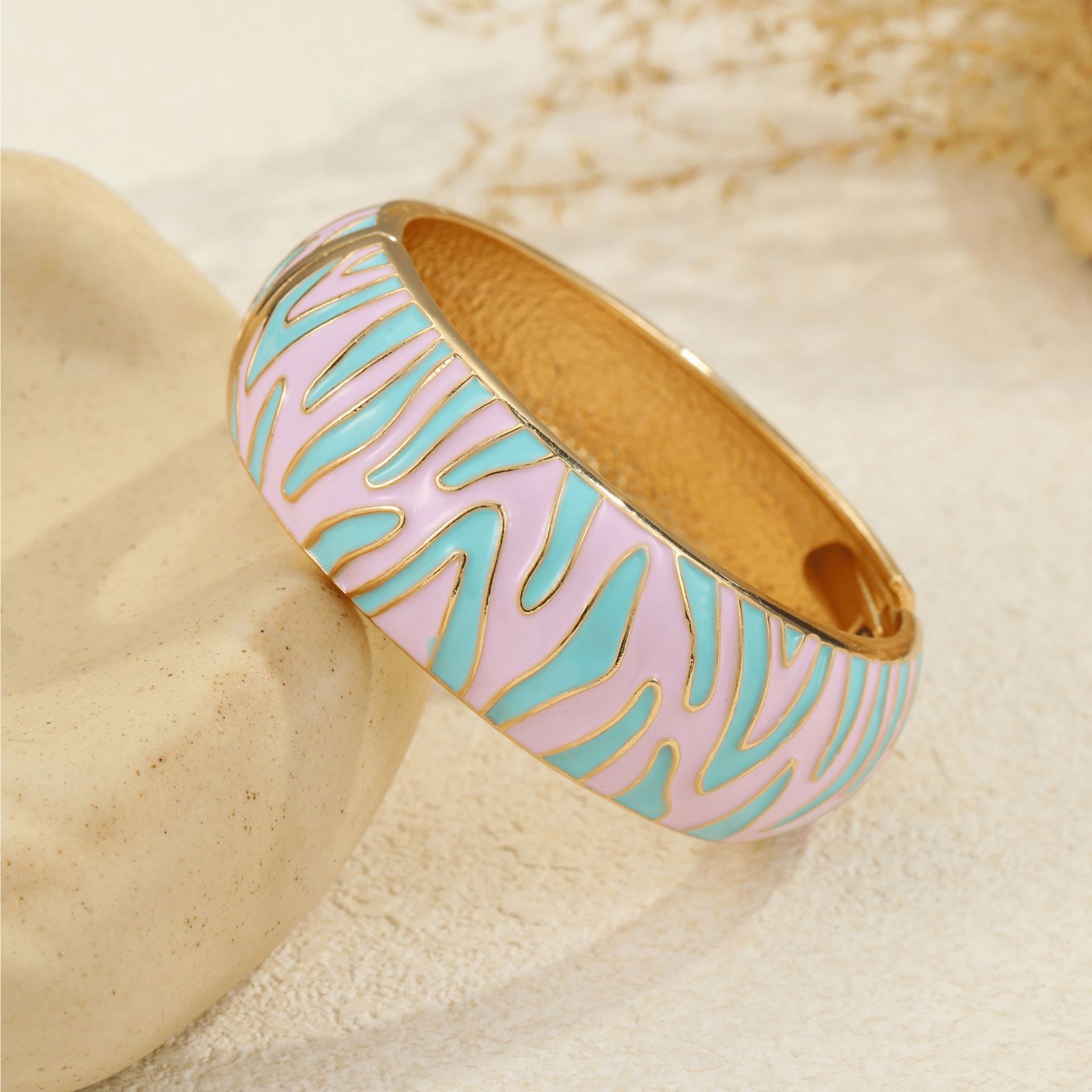Base rosa claro chapada en oro con estampado de cebra azul menta
