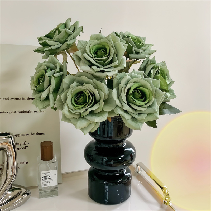 7 fleurs vert rose dans un vase en verre noir