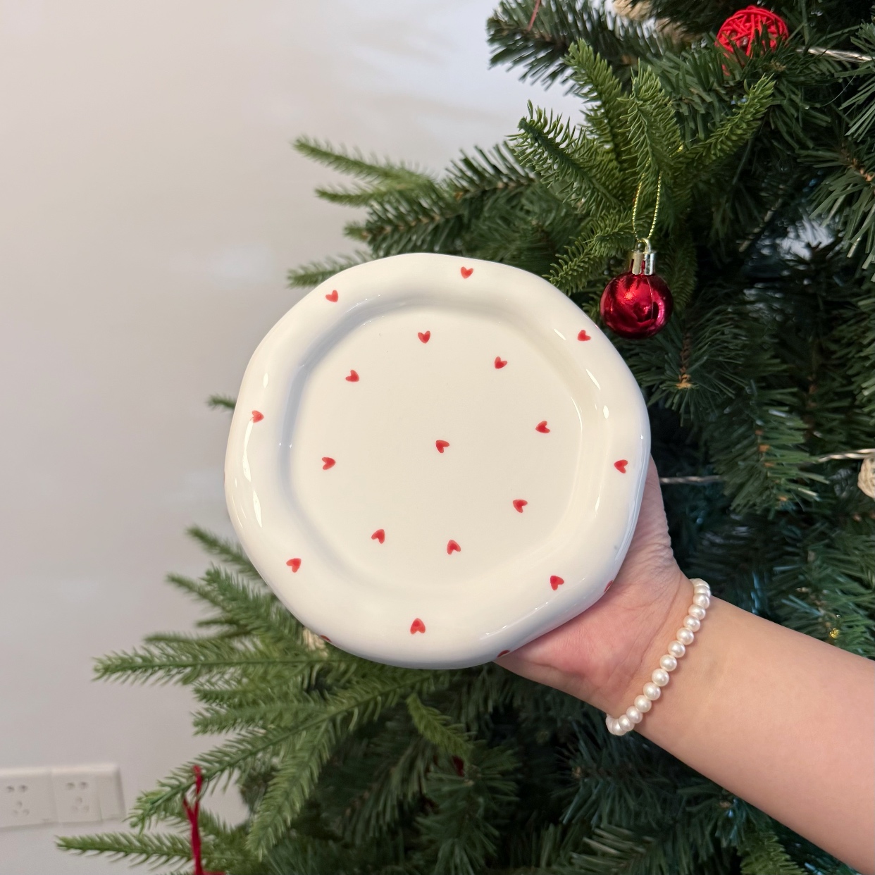 Plato pequeño blanco con corazón rojo.