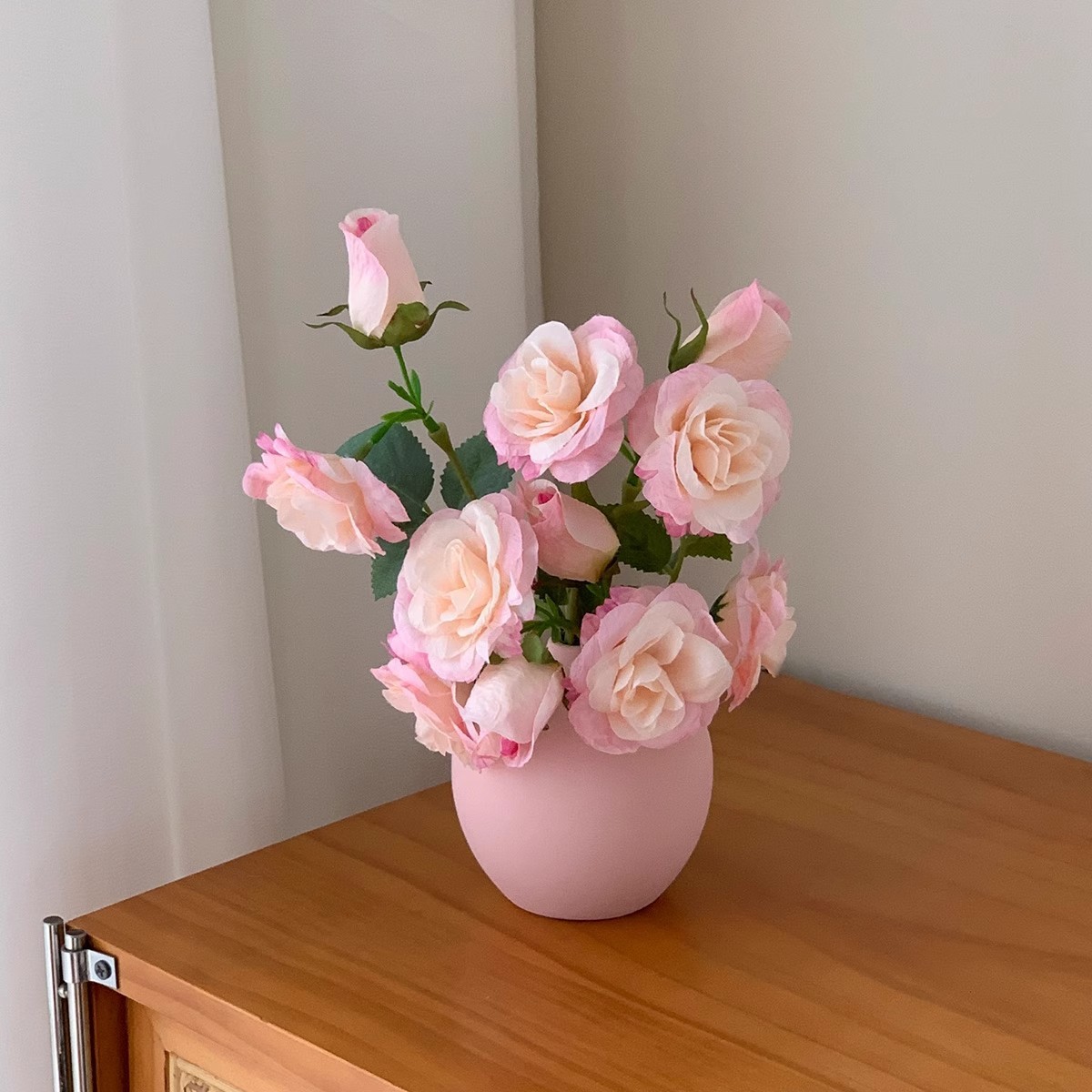 Bouteille en céramique rose avec bouquet de roses roses