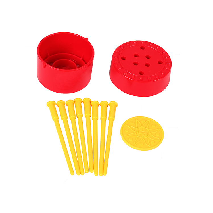 Boîte ronde rouge avec clou jaune et pièce de monnaie.