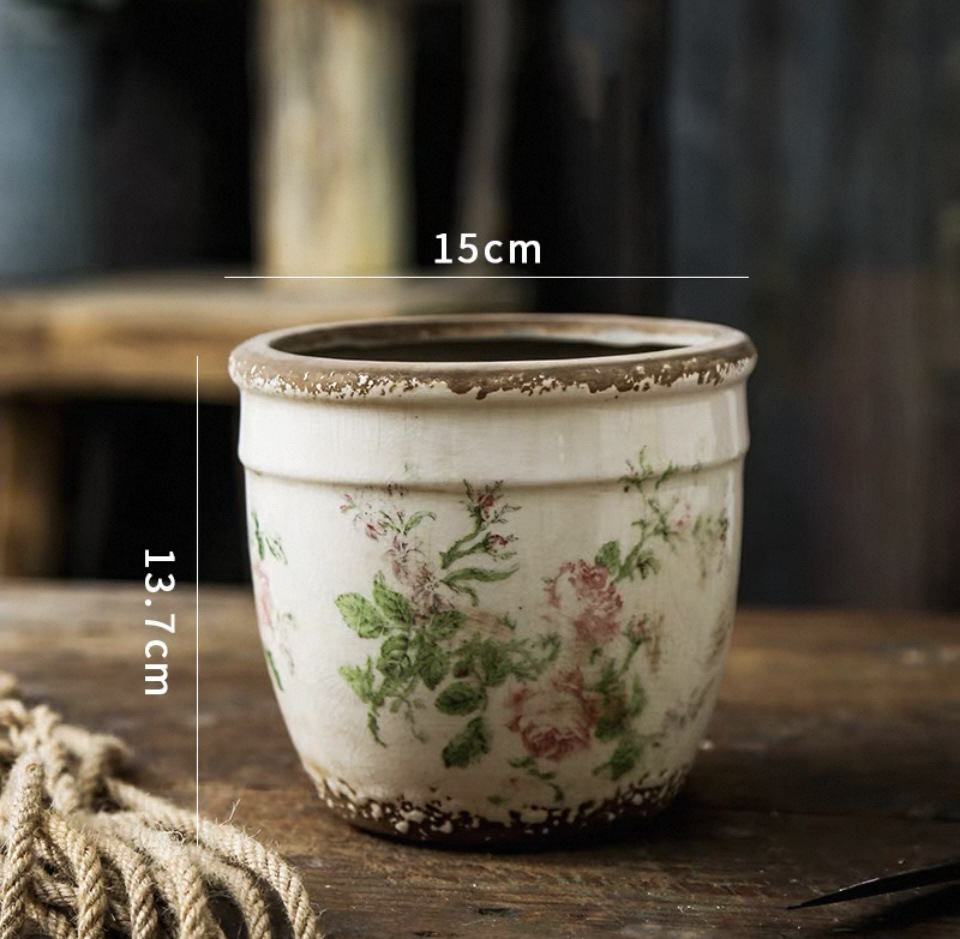 Maceta de 1315 cm con flores rosas y orificios de drenaje