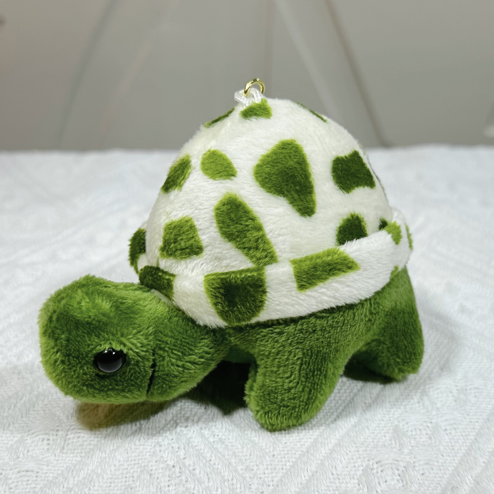 Tortuga de peluche - puntos dorados en el botón, cuerpo verde, puntos verdes.