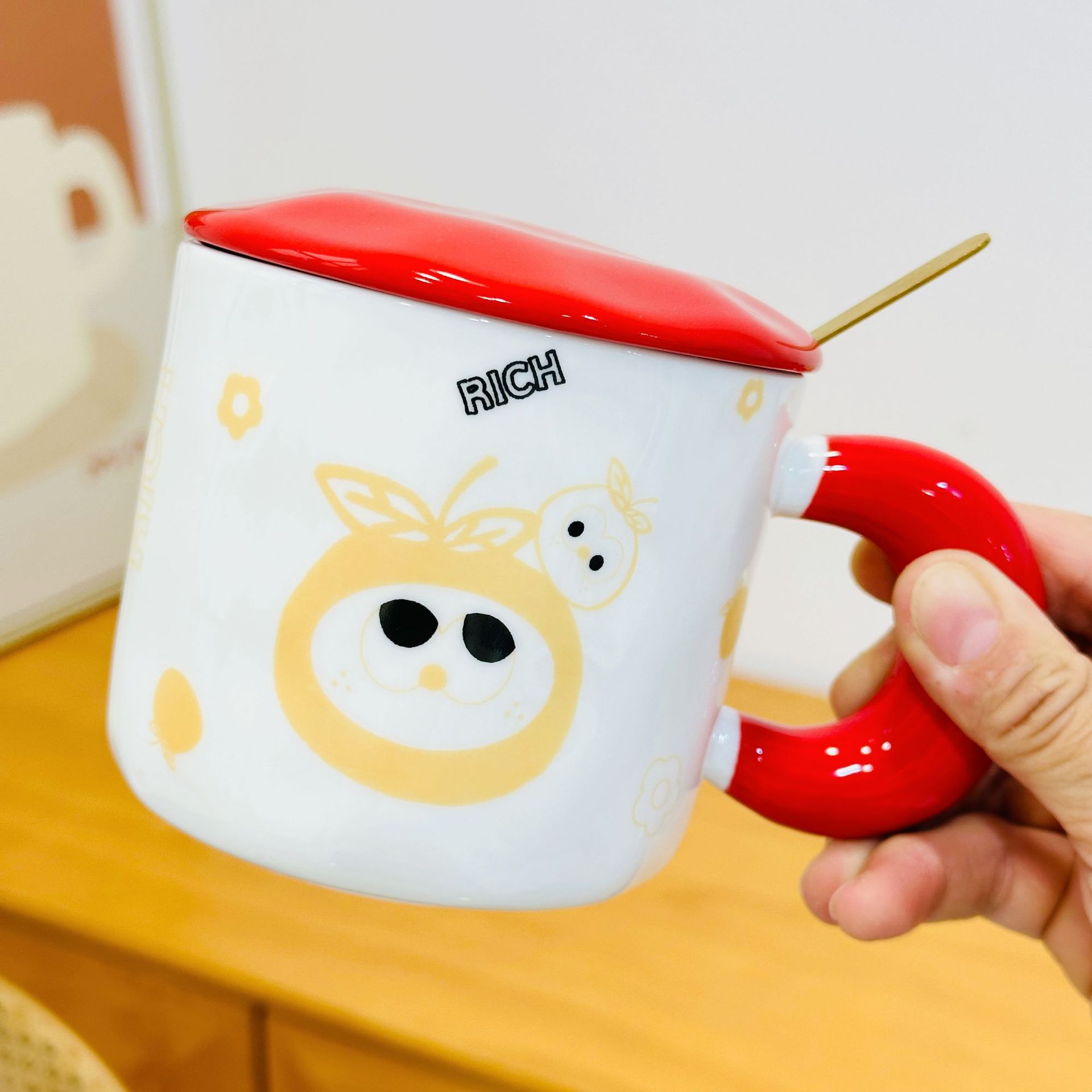 Tasse en céramique rouge orange en haut à droite avec couvercle et cuillère
