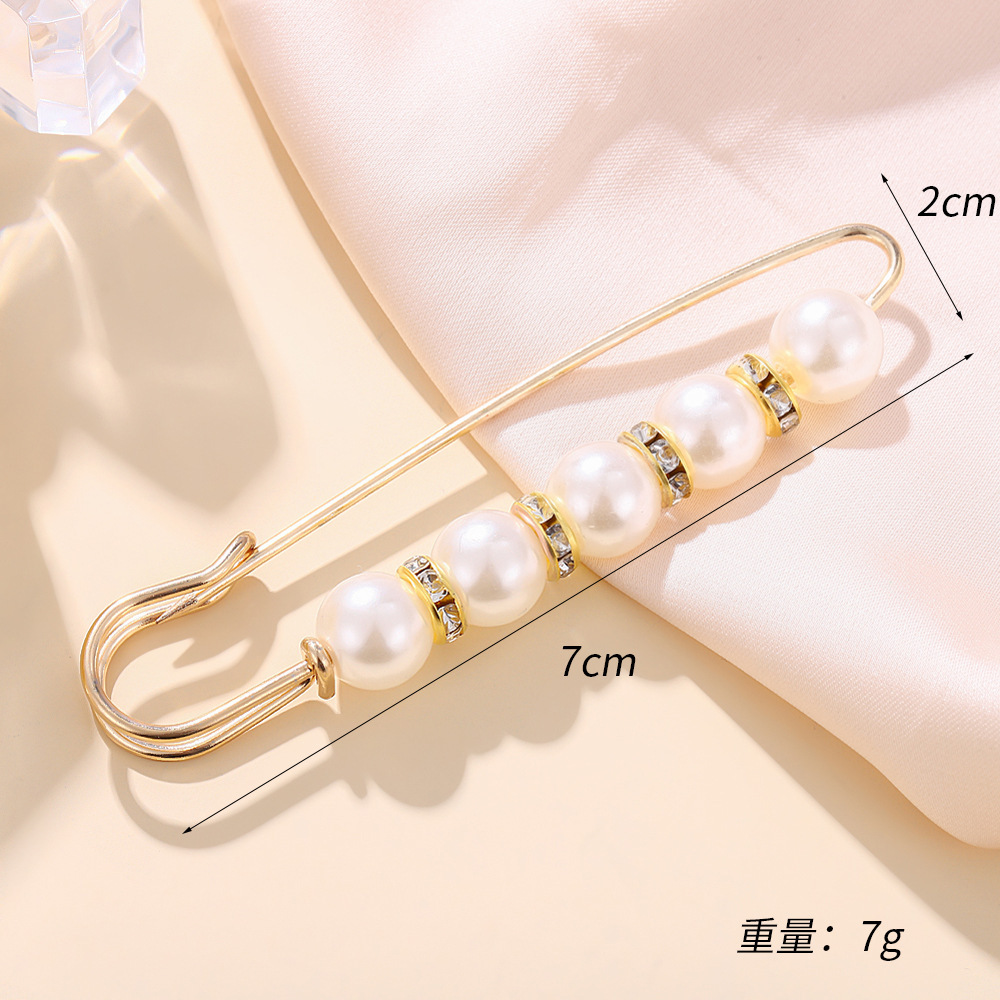 Broche blanche cinq perles et strass