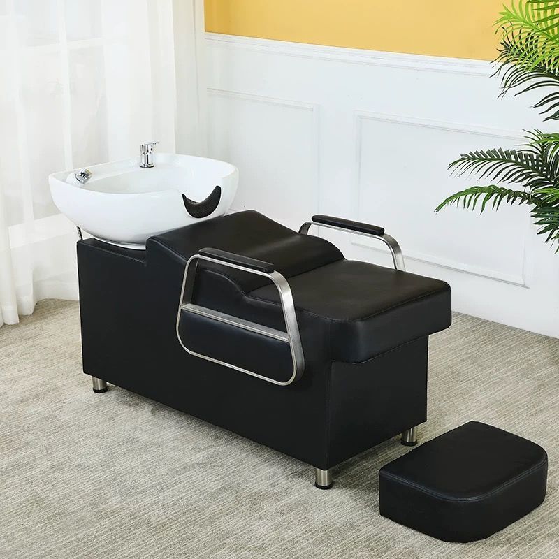 Cama negra, lavabo de porcelana blanca.