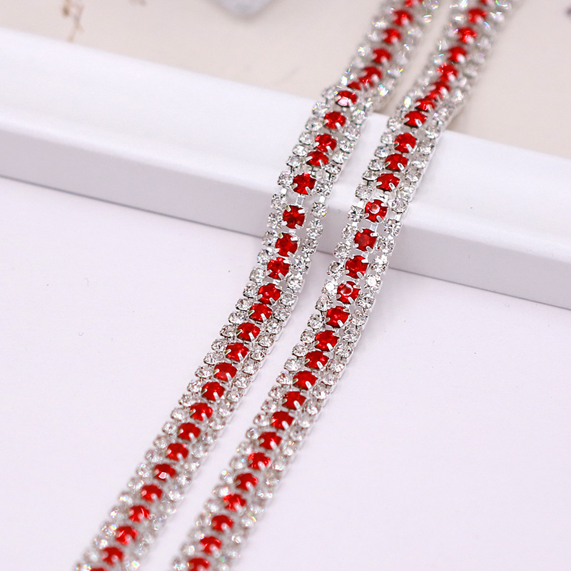Base argentée avec trois rangées de larges motifs rouges et blancs.