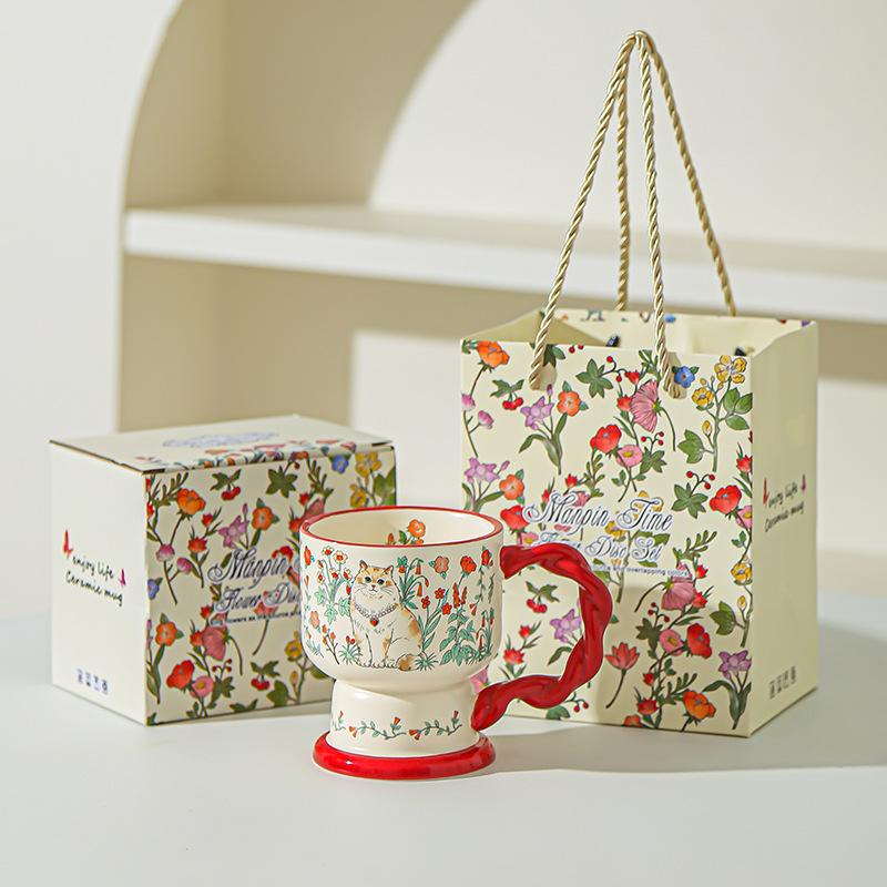 Tasse rouge de chat de buisson de fleur (tenu dans la main)