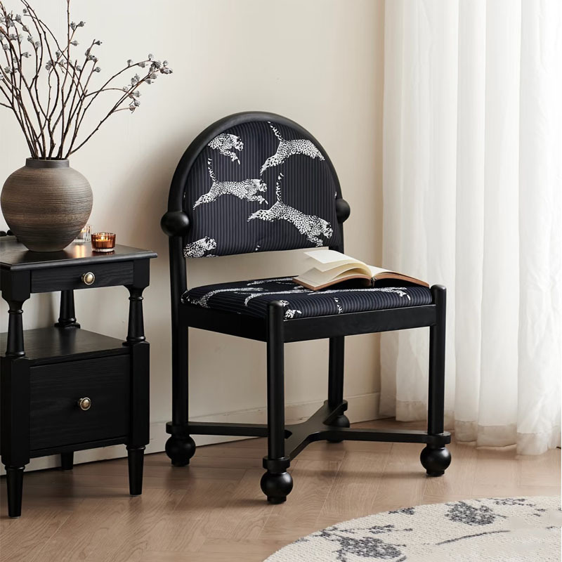 Fauteuil boule noir cendré à motif léopard bleu.