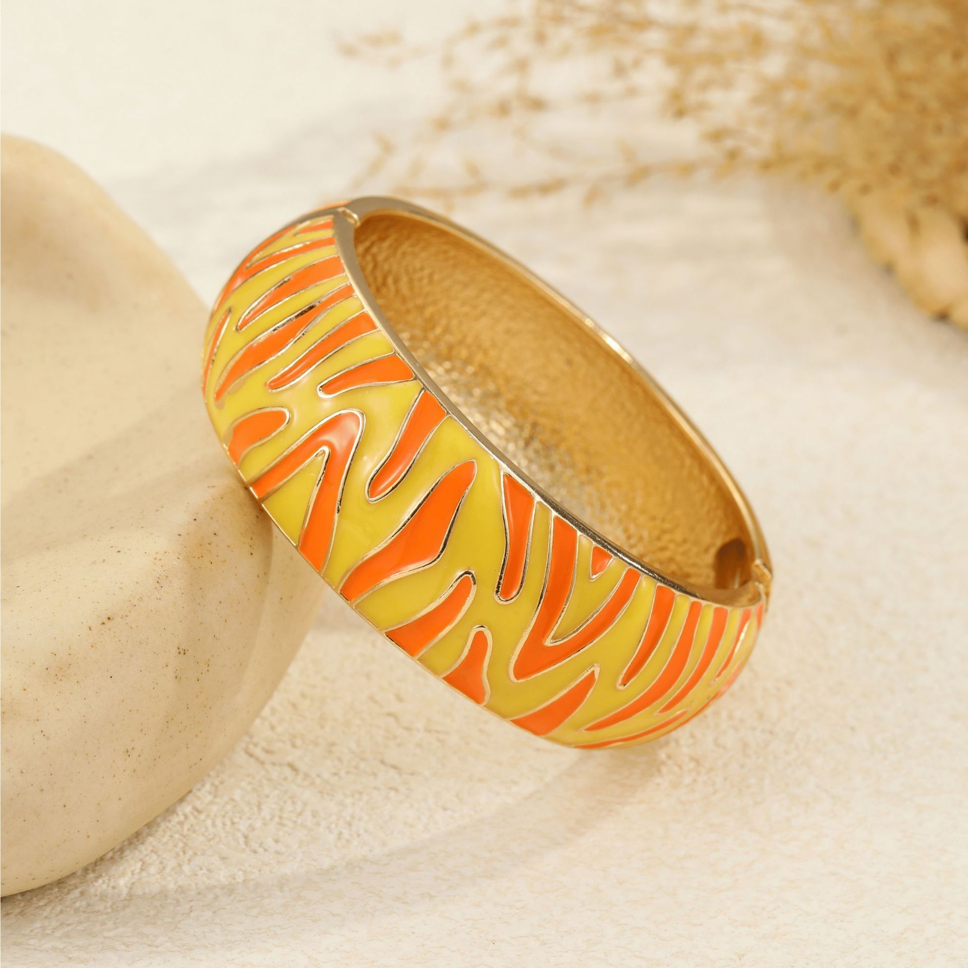 Base dorada con rayas de cebra en amarillo, naranja y rojo.