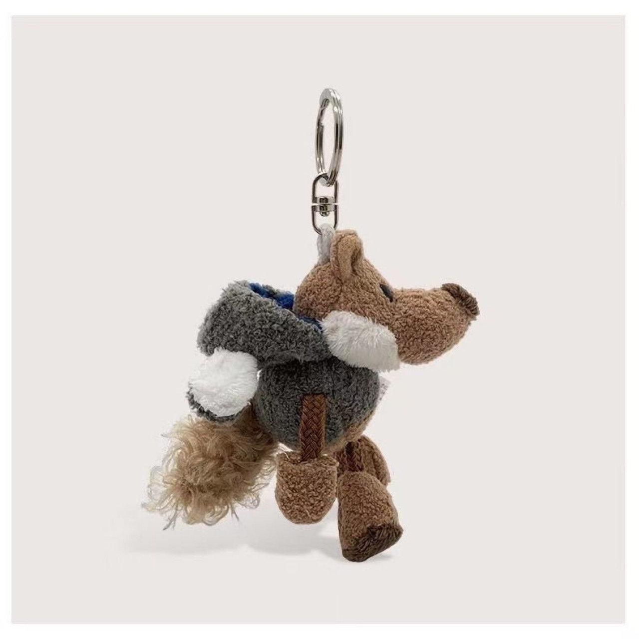 La petite poupée loup portant un manteau à capuche gris ardoise