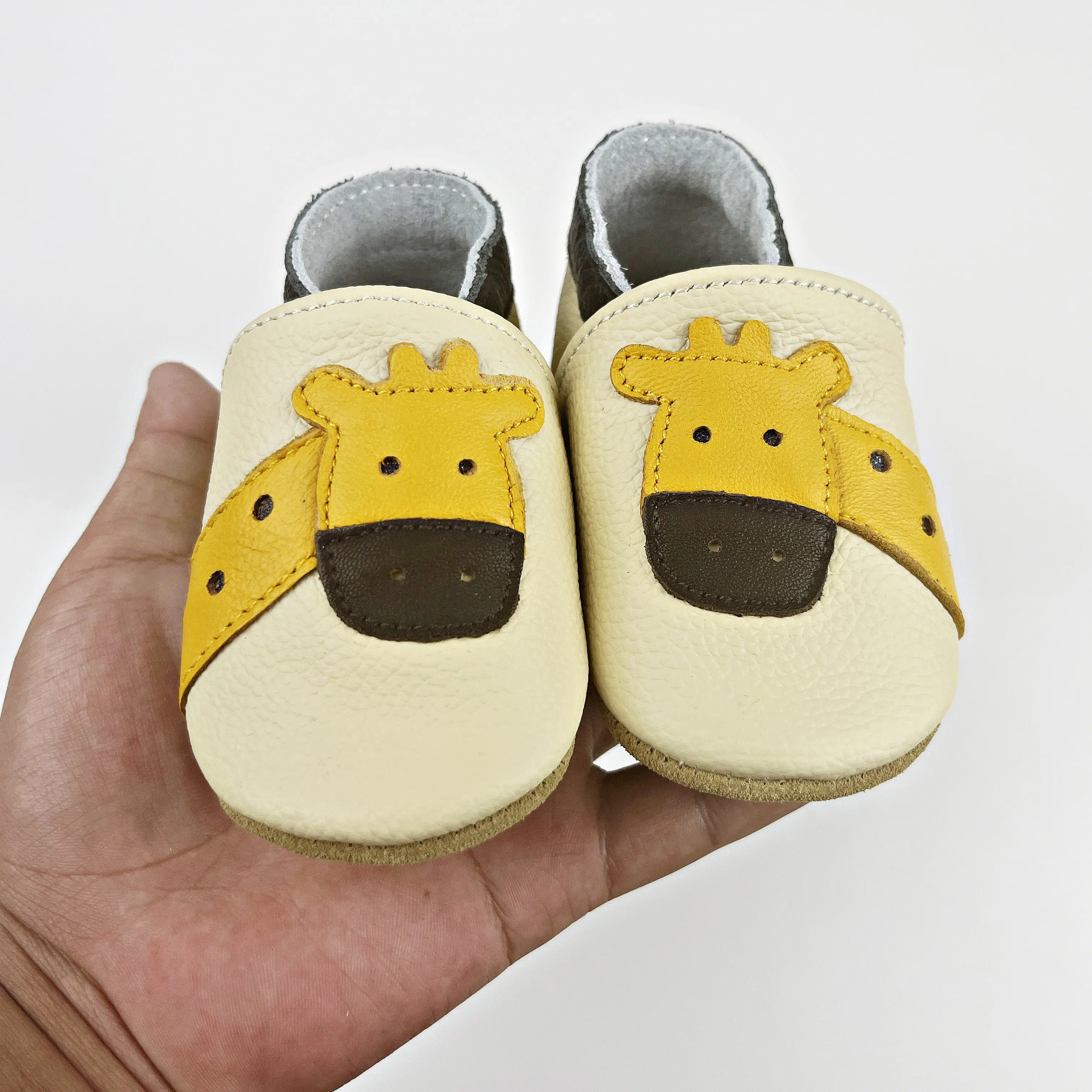 Bede, nuestros bonitos zapatos de aprendizaje para bebés con forma de jirafa al por mayor, zapatos de cuero para bebés de suela blanda para interiores, piel de vaca