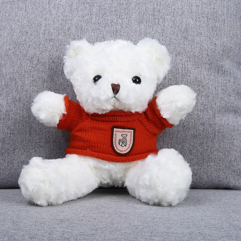 Orso bianco dai riccioli, vestito di rosso.