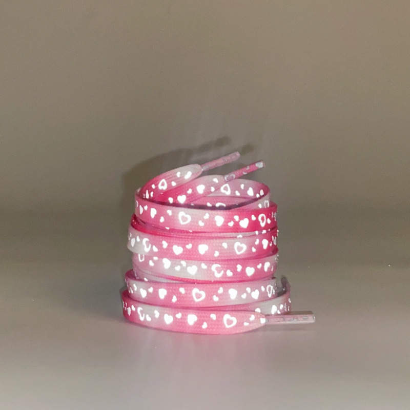A pair of red pink reflective love shoelaces