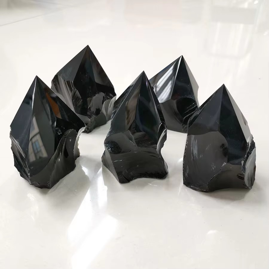 Pointes d'obsidienne noire brute, brillantes et polies