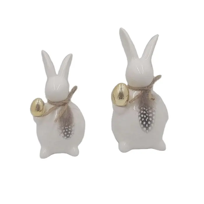 イースターの装飾のための黄金の卵と白い磁器セラミックウサギ