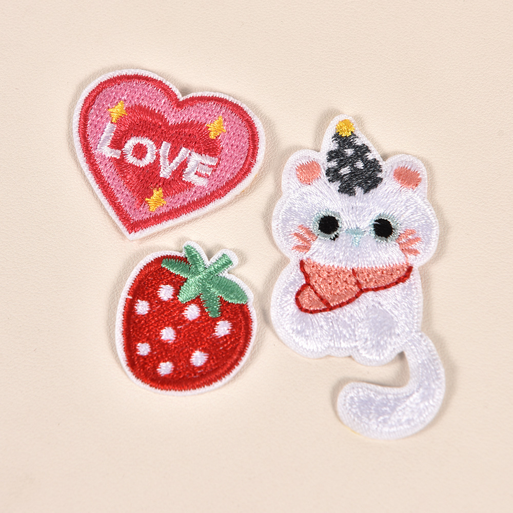 Parche bordado de gato blanco y fresa en forma de corazón.