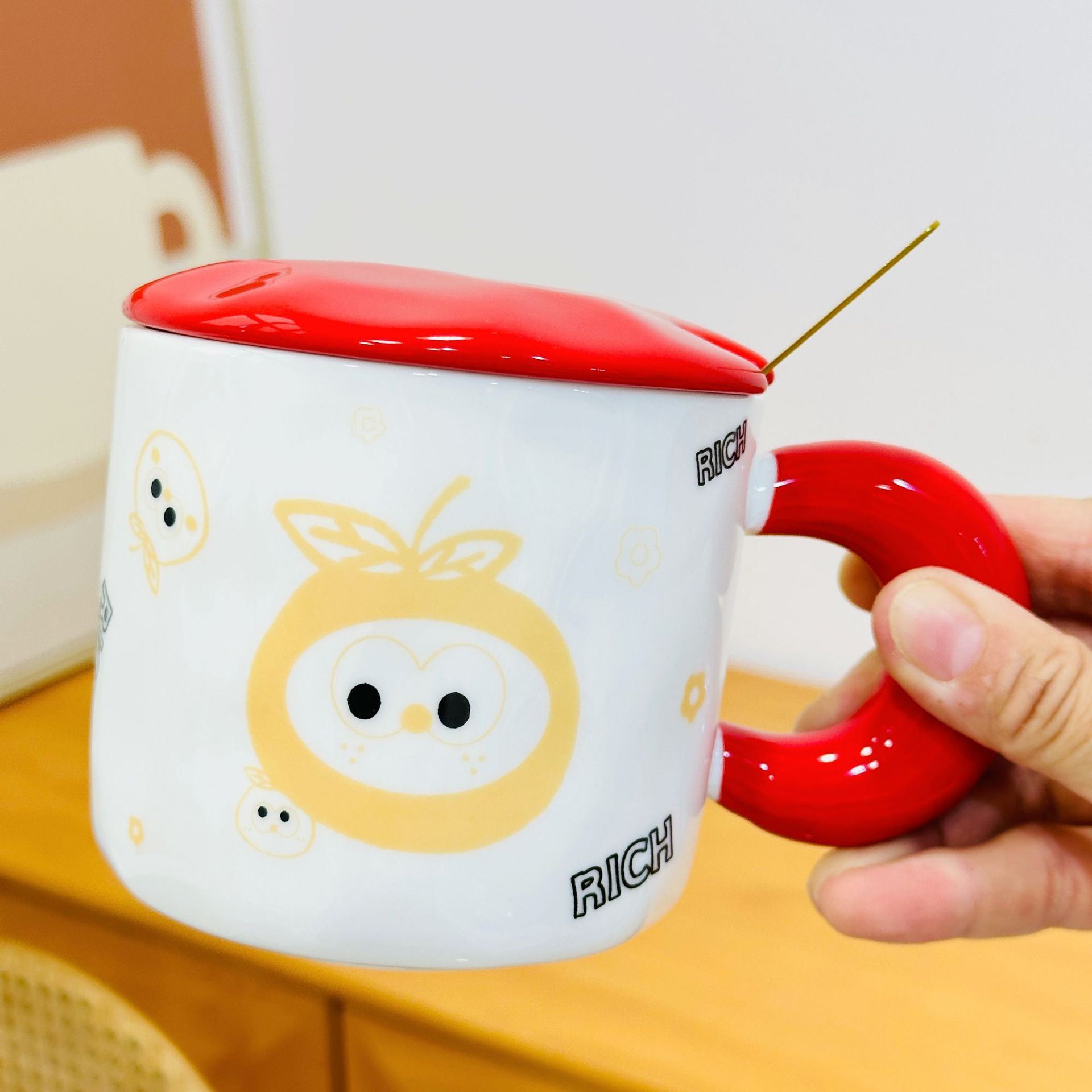 Tasse en céramique rouge orange inférieure gauche avec couvercle et cuillère