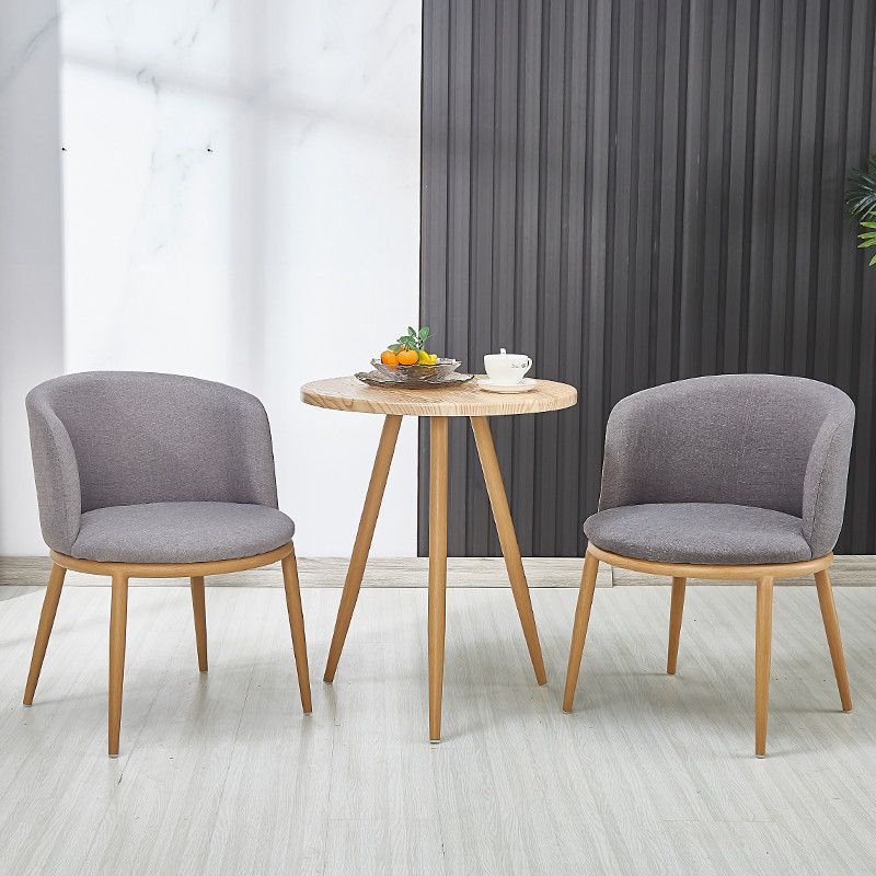 Une table grise avec des pieds de couleur claire et deux chaises