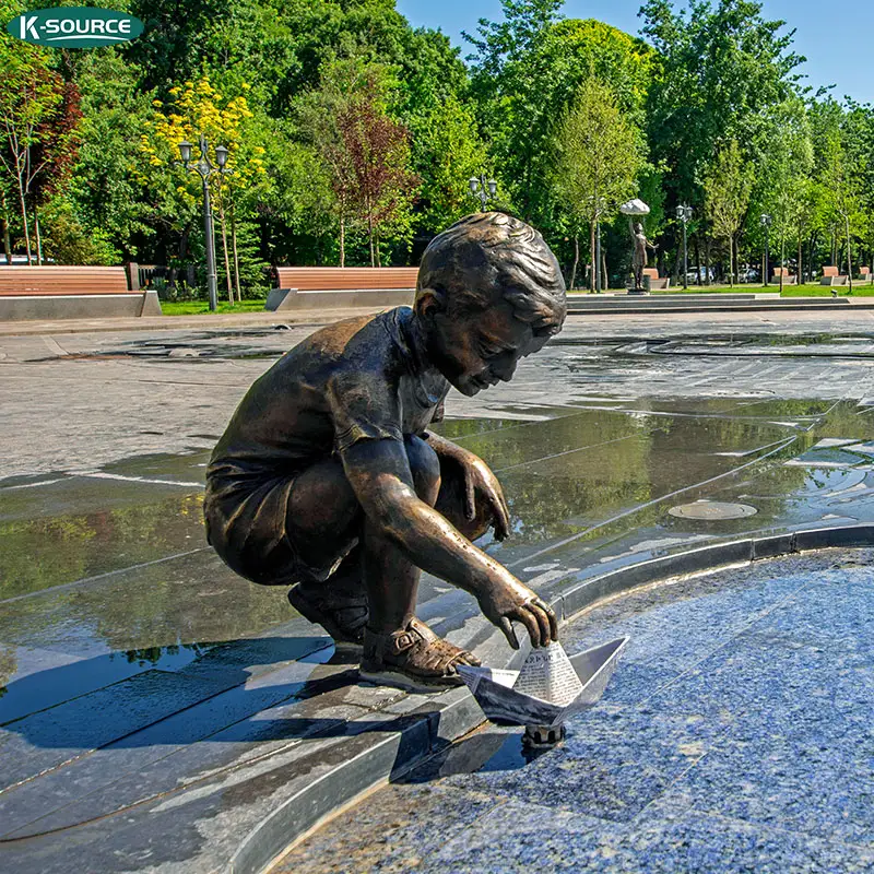 Estátua bronze de decoração do parque de feliz menino jogar com barco de papel