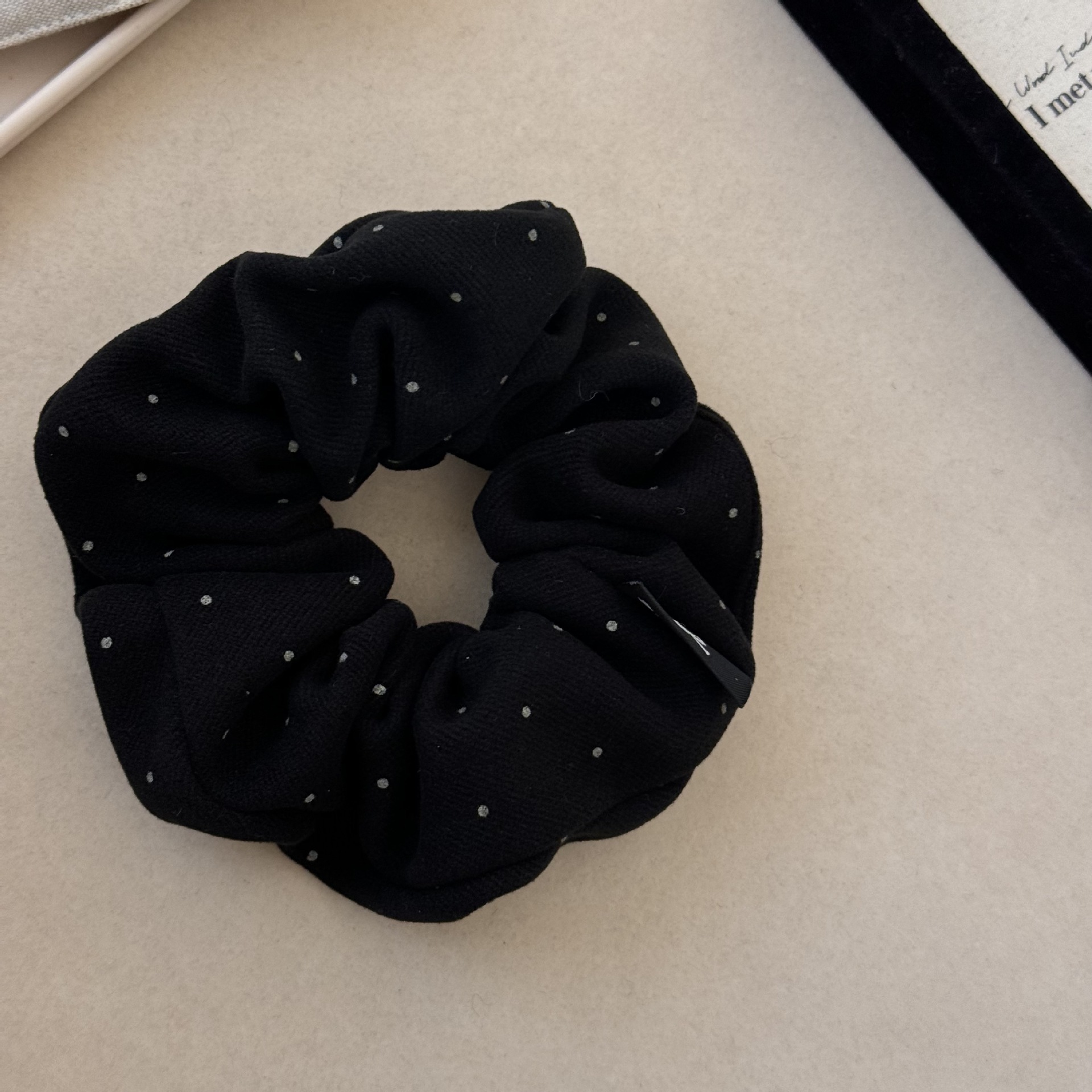 Anillo para el cabello con diseño de onda negra y puntos.