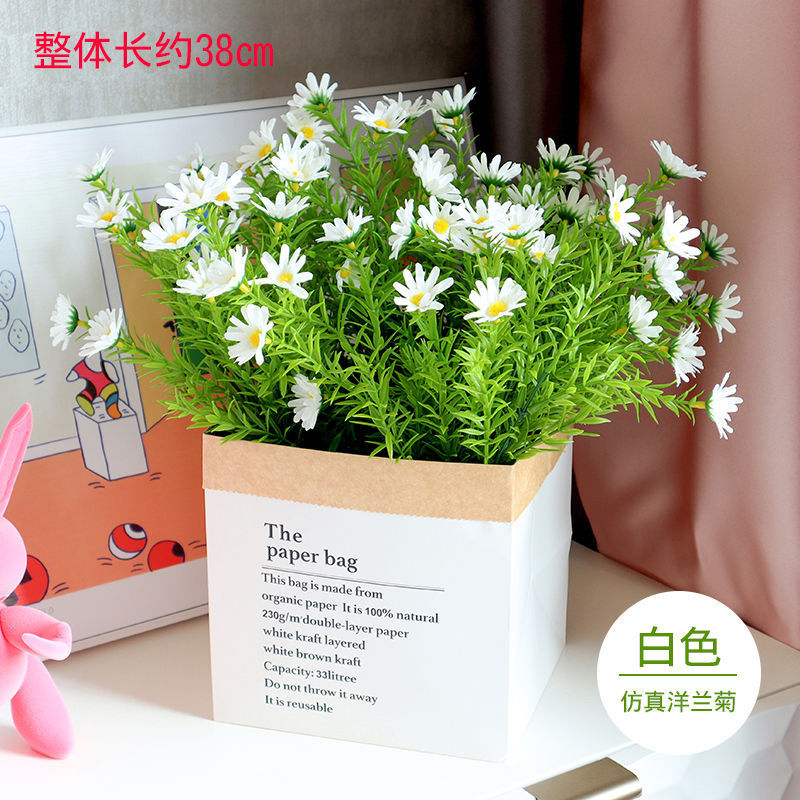 Trois bouquets de camomille blanche dans un petit sachet en papier kraft
