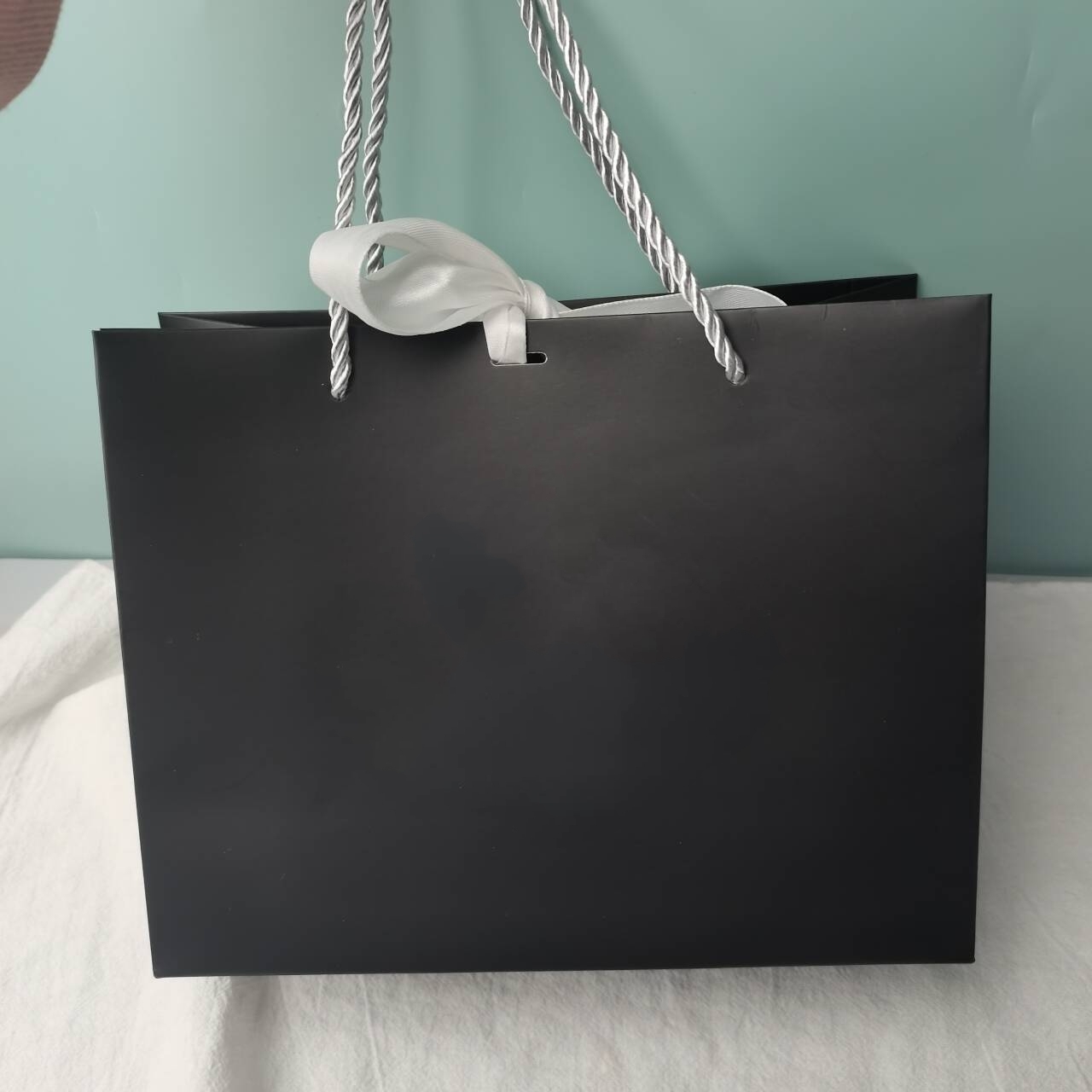 bolsa de papel negro con lazo