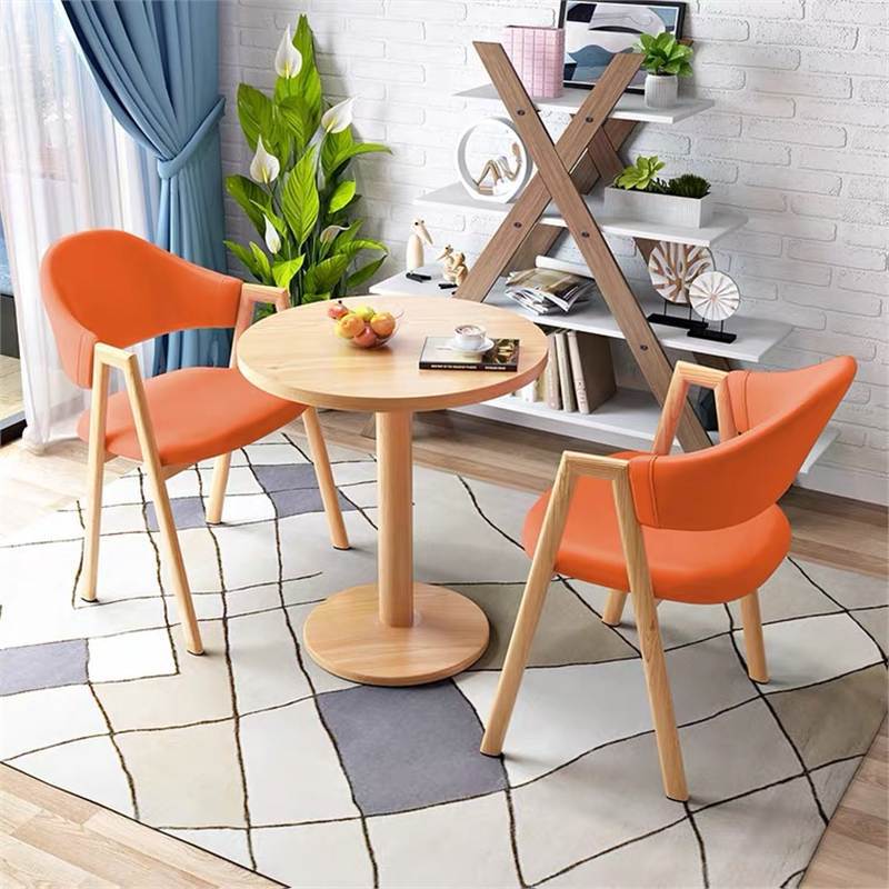 Mesa redonda naranja claro de 60cm y 2 sillas de cuero.