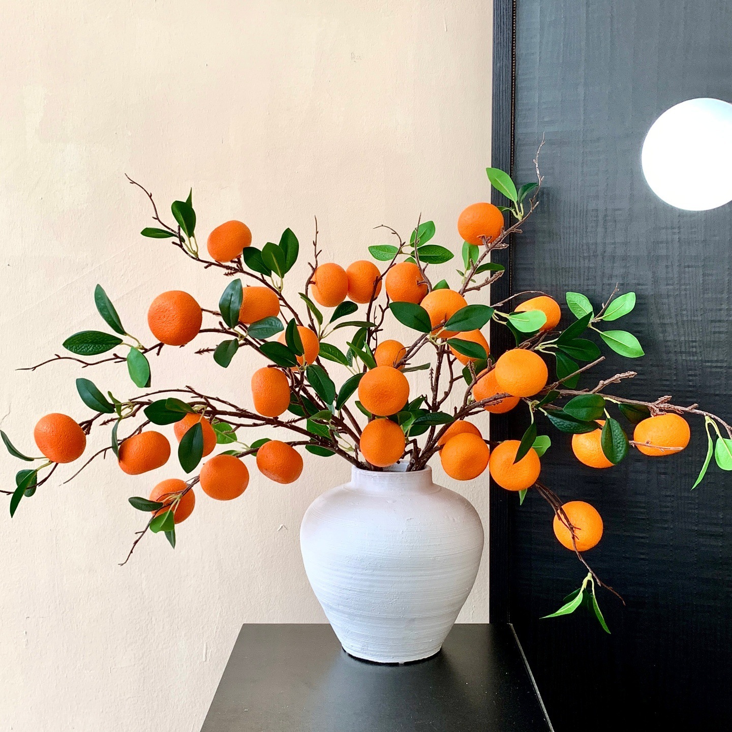 6 naranjas y 5 tarros de cerámica blanca.