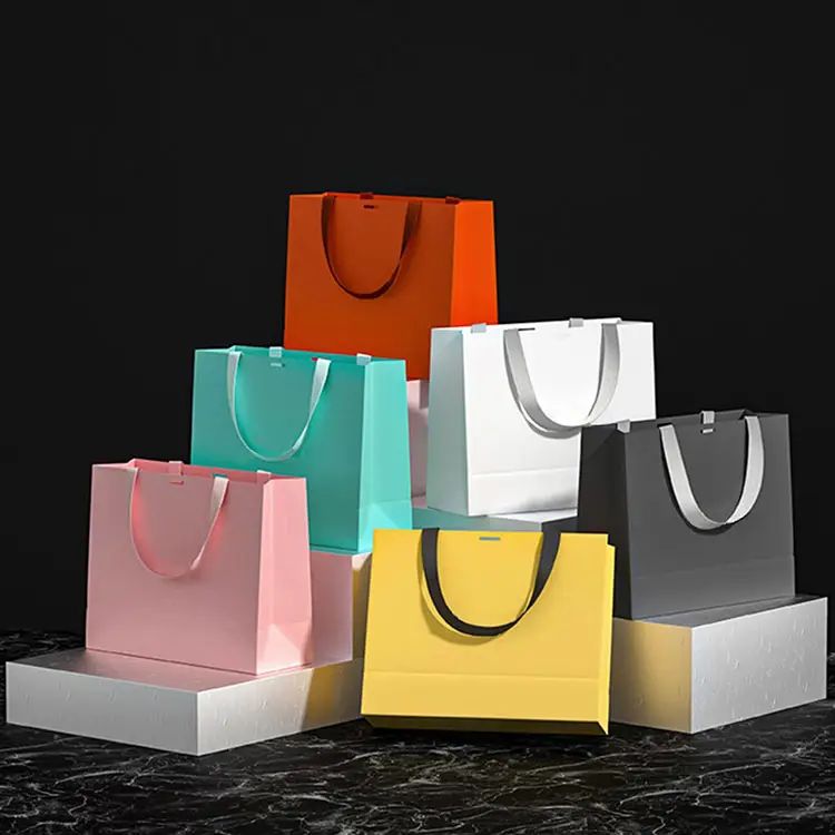 कस्टम लोगो प्रिंट लक्ज़री ग्लॉसी क्लॉथ जूते हैंडबैग हैंडल के साथ विशेष पेपर शॉपिंग बैग