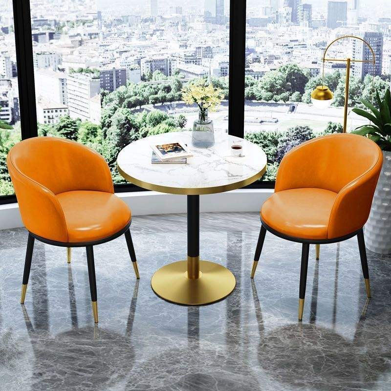 Chaise en cuir orange, table ronde imitation pierre.