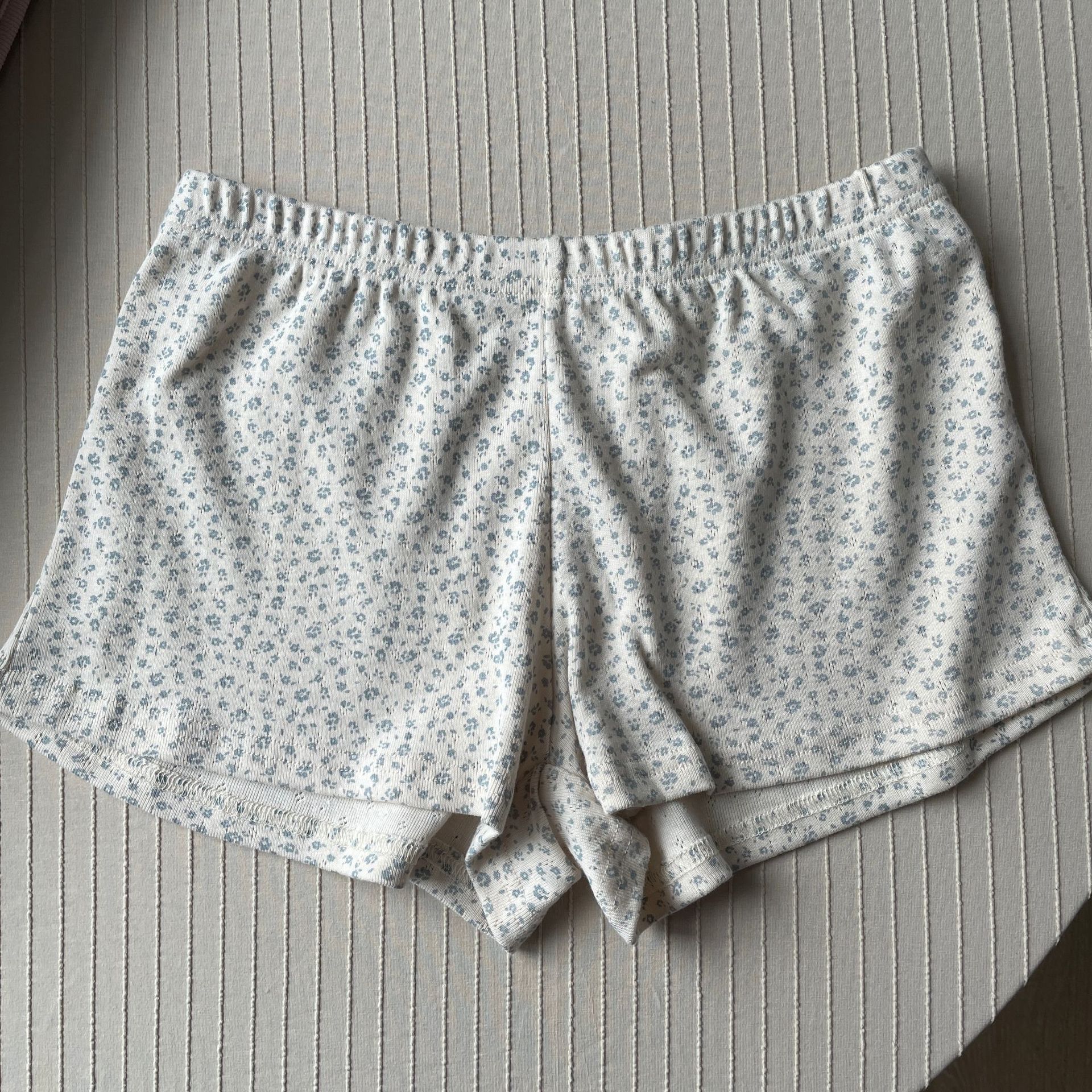 Fondo albicocca con fiore blu: pantaloncini