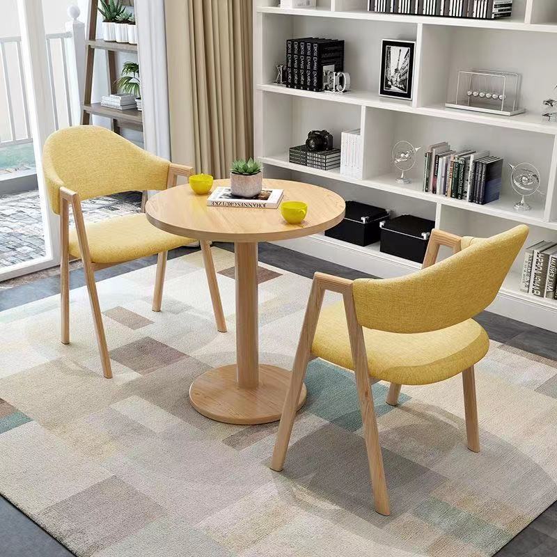 Mesa redonda de 60 cm de color amarillo claro con 2 sillas de tela.