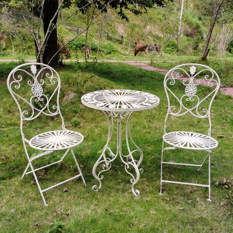 Ensemble rétro blanc composé d'une table et de deux chaises anciennes.