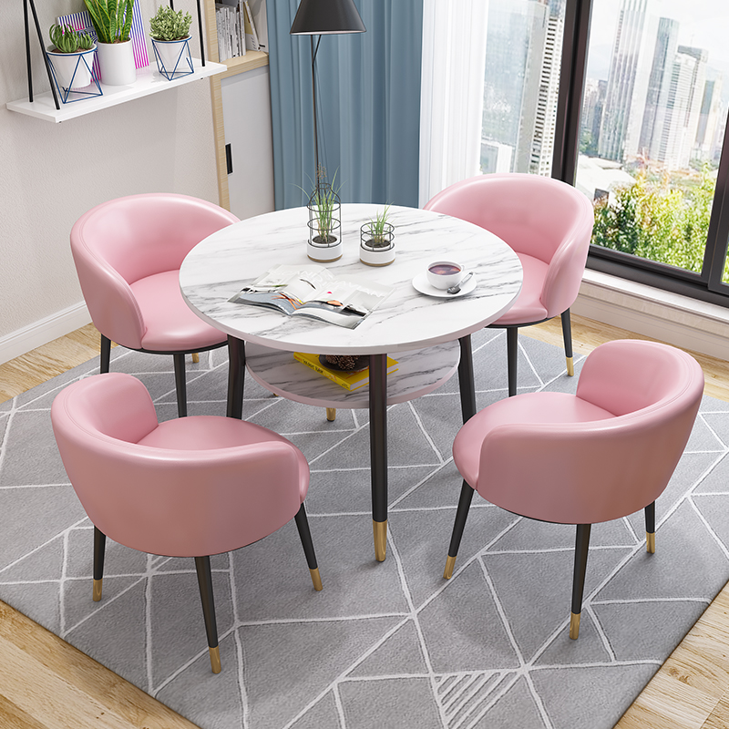 Silla con patas de cuero negro y dorado, una silla rosa