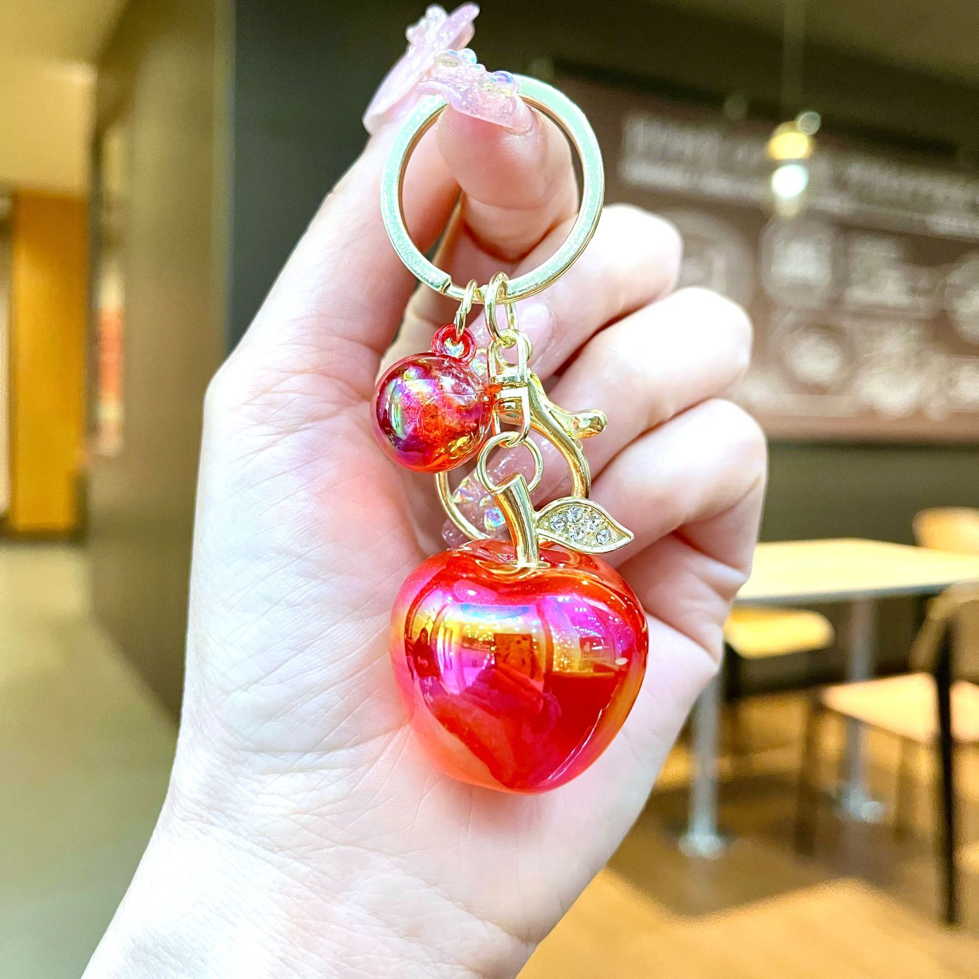 Pomme plaquée rouge avec détails dorés.