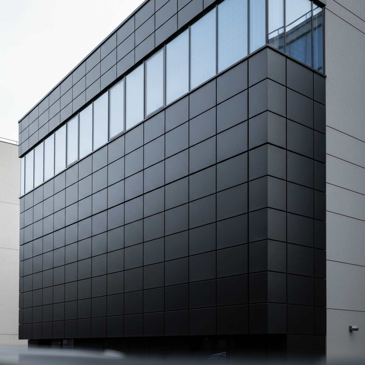 Sleek modern building facade with integrated matte black vertical solar heaters.