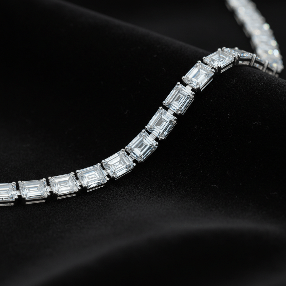 Emerald-cut moissanite chain with hall-of-mirrors effect on dark velvet.
