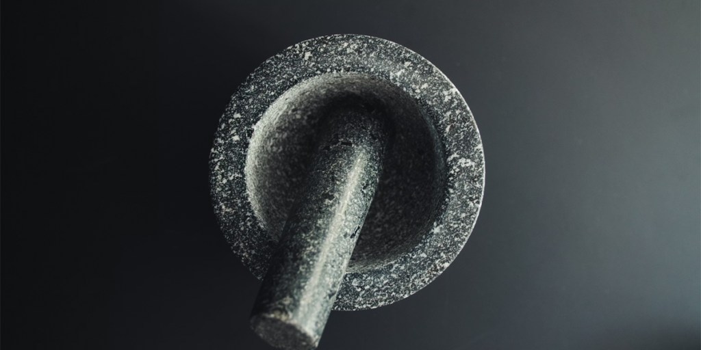 Mortar and pestle from above on a black background
